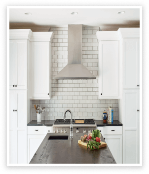 kitchen renovation white cabinets hooded stainless steel vent over stove island
