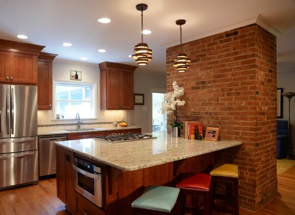 After photo of a kitchen remodel project with marble countertops with brick chimney