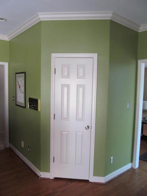 before photo of green hexagonal wall with white door