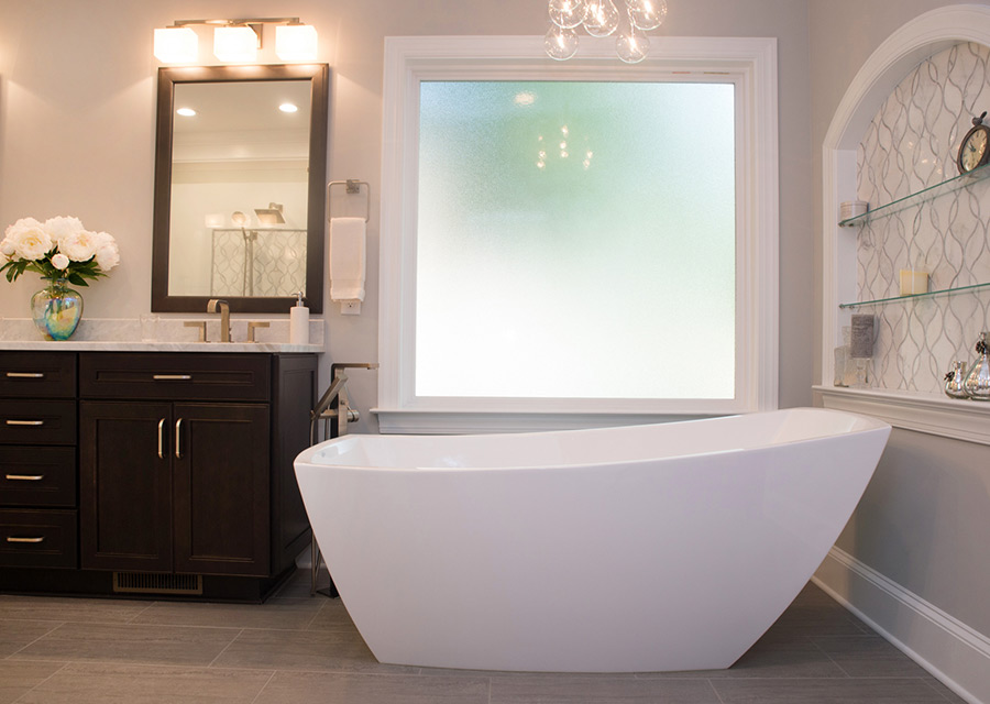 Upgraded bathroom with free-standing tub, large frosted glass window, custom built-in niche, and black vanity