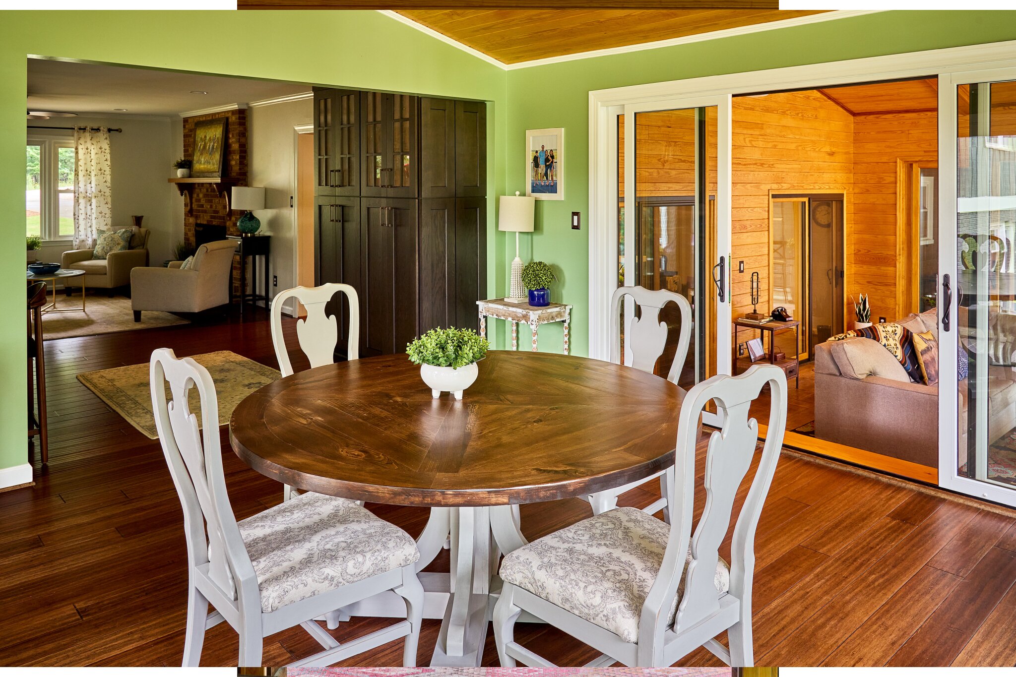 view of living room dining room sunroom green painted walls hardwood flooring sliding doors