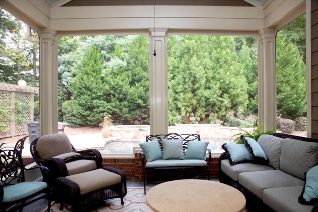 Sun porch with large windows facing the trees in the backyard.