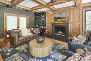 Vintage style living room with built in fireplace and wood paneling on walls.